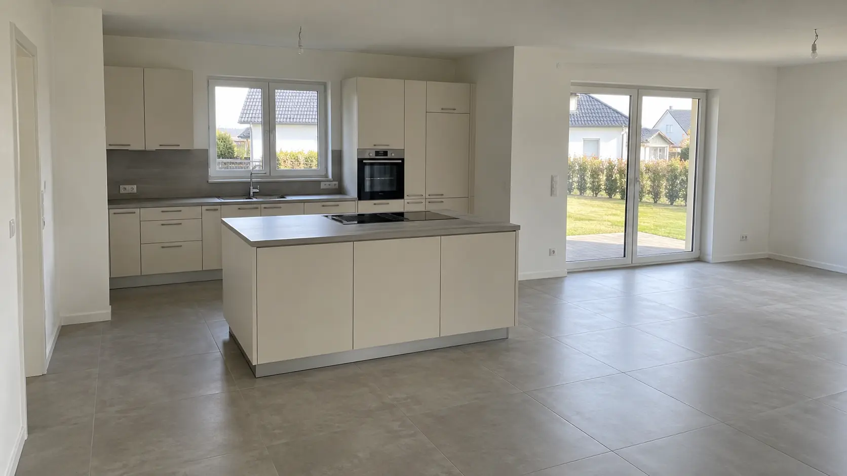 Offene Wohnküche mit Kochinsel und Terrassentür zum Garten