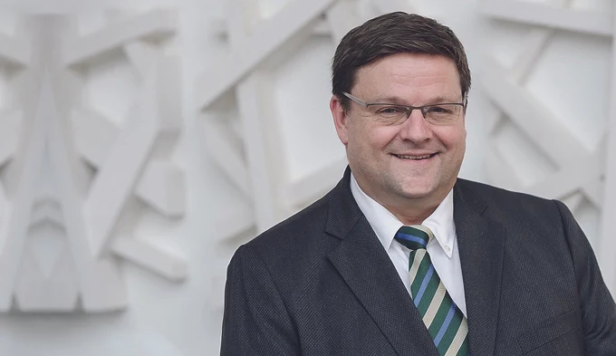 Volker von Witzleben, Vorstand der Witzleben AG, lächelnd im dunklen Anzug vor einer hellen Reliefwand
